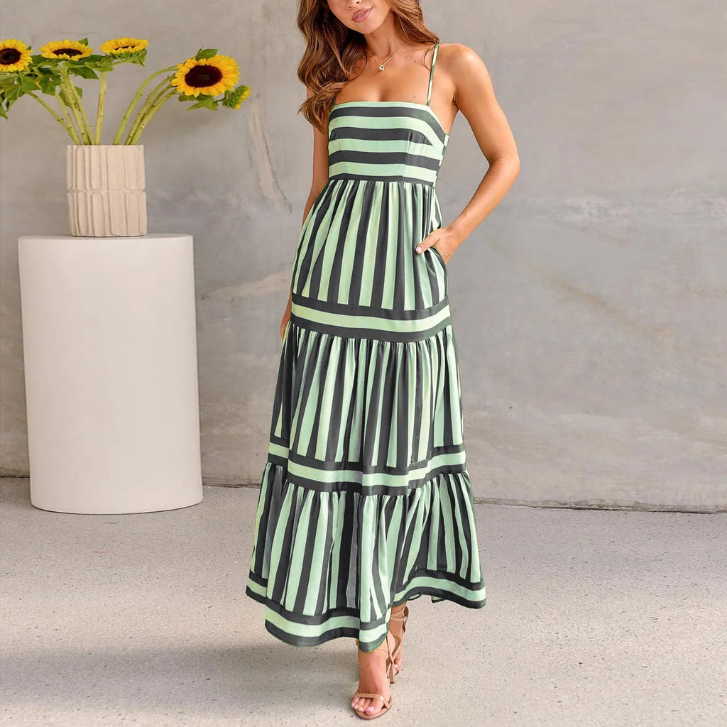 A woman wearing a striped backless suspender summer dress with a square neckline and side pockets.