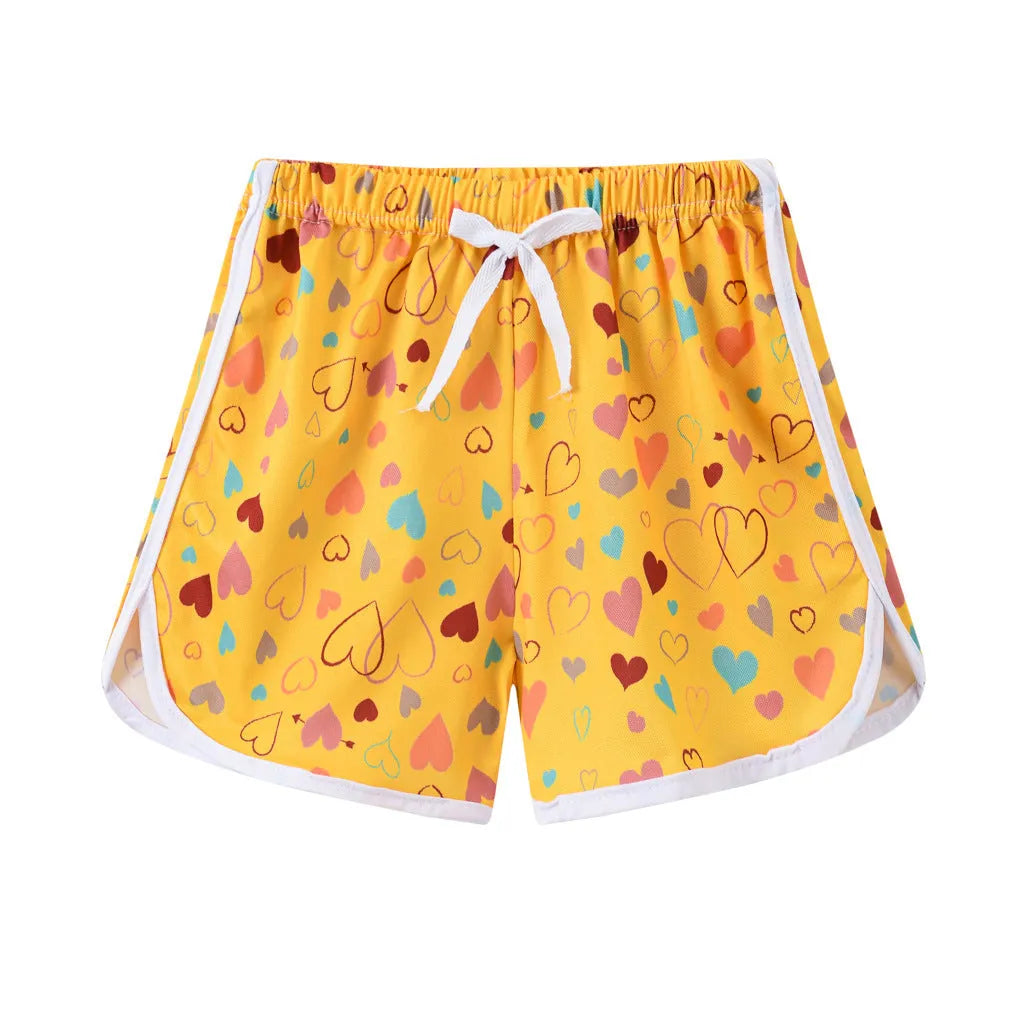 Children's patterned beach shorts in various colours including leopard print, floral, and fruit designs