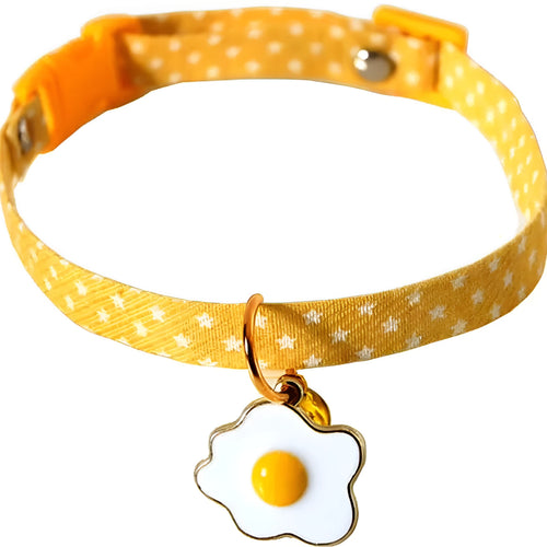 Green adjustable pet collar with a metal bell and a pink bow tie attached, shown on a small dog.
