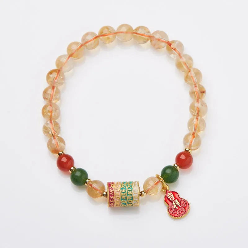 Hand-woven citrine five sutra bracelet with 6mm geometric beads on a wrist.