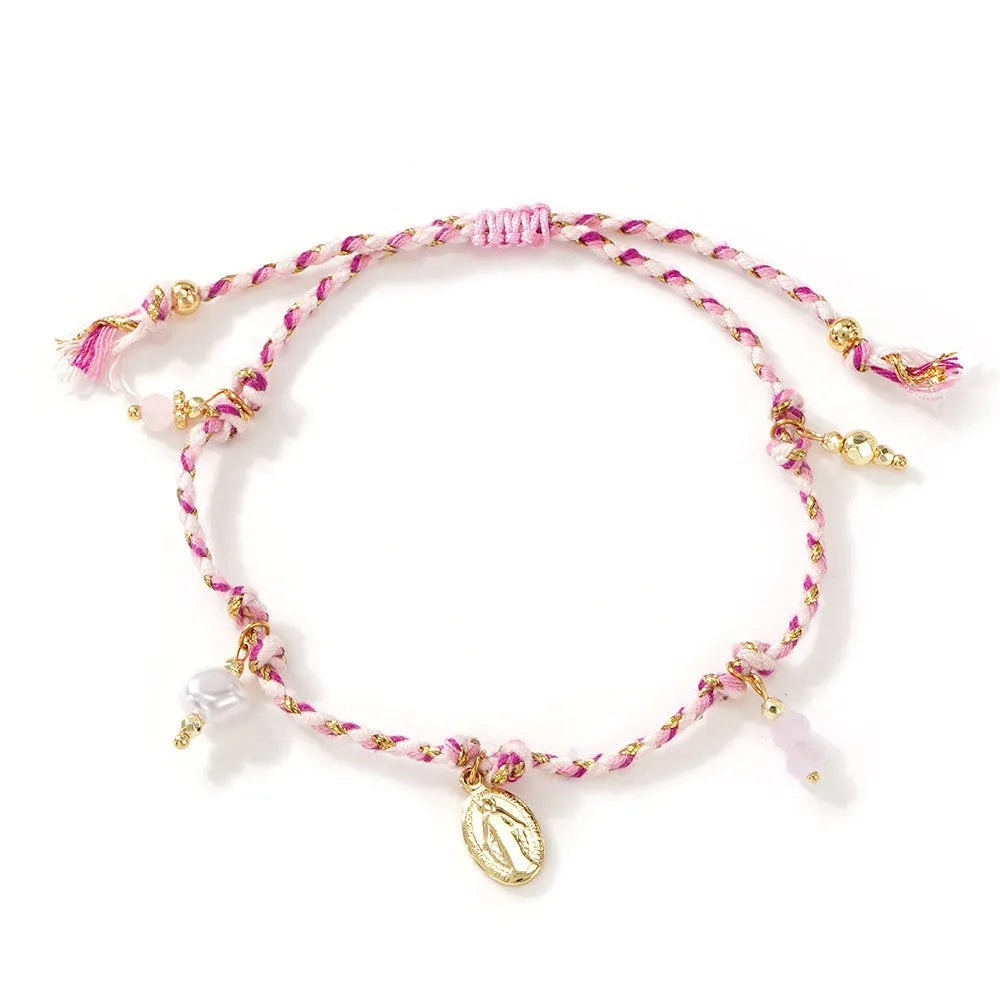Close-up of a woman's hand-woven colourful braided rope bracelet with an adjustable strap tag.