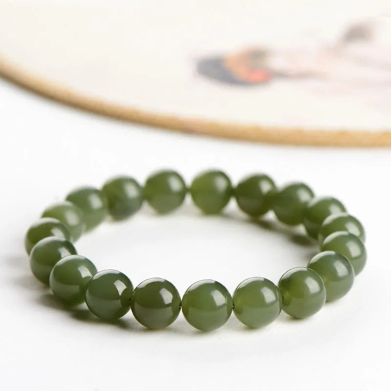 Polished Hetian jade ball bead bracelet in light and deep clear water colours on a wrist.