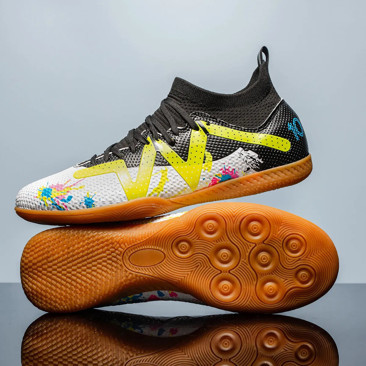 Lining low-top football boots in black and yellow with spiked rubber sole, showing mesh and PVC upper construction.