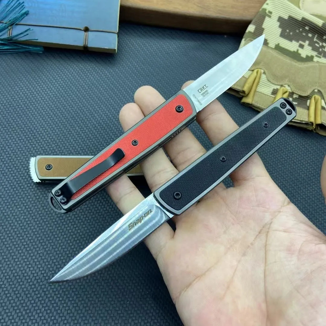 Closed and open views of a black folding fruit knife showing blade and handle.