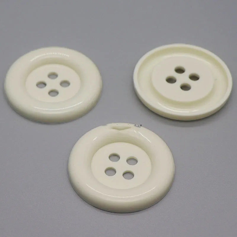Oversized round plastic button with four holes in various colours and sizes from 38mm to 70mm.