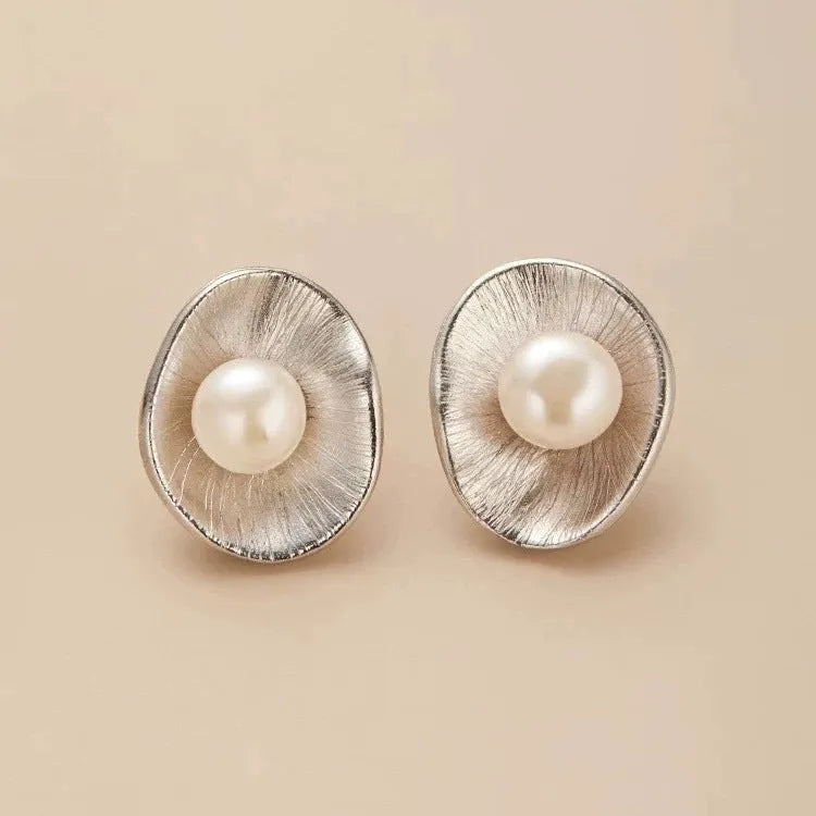 A pair of gold-coloured geometric sterling silver stud earrings featuring a single pearl.