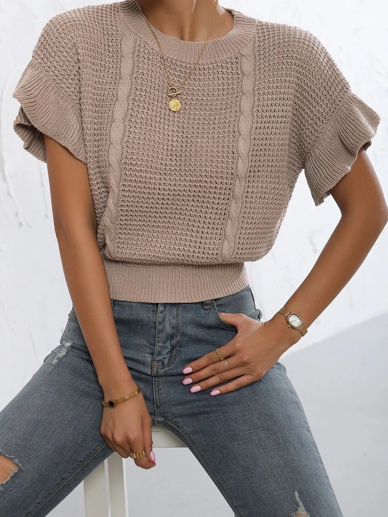 Loose white knitted pullover sweater with detailed twisted string ruffled short sleeves, round neck.