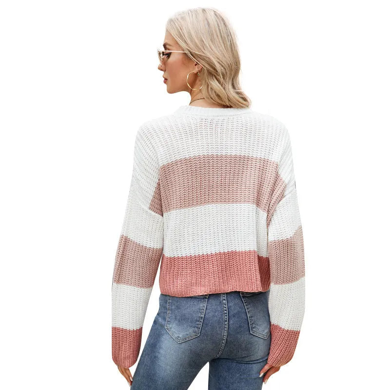 Short, loose-fitting striped women's pullover sweater on a hanger.