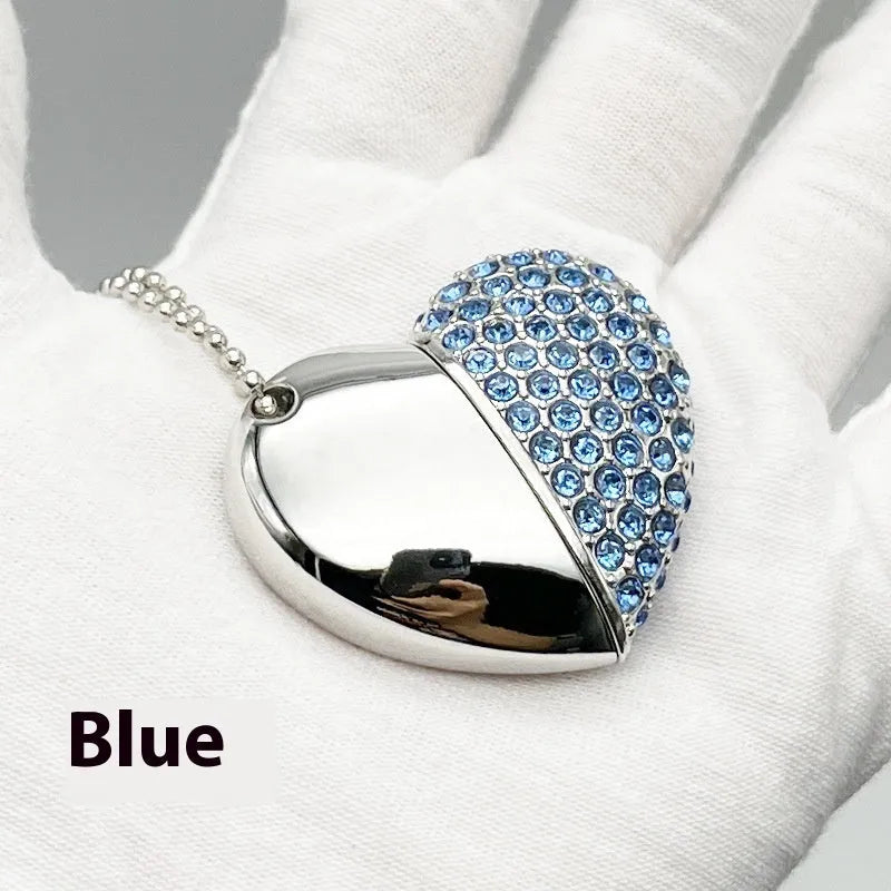 A heart-shaped silver USB flash drive with a brick pattern, shown next to a laptop.