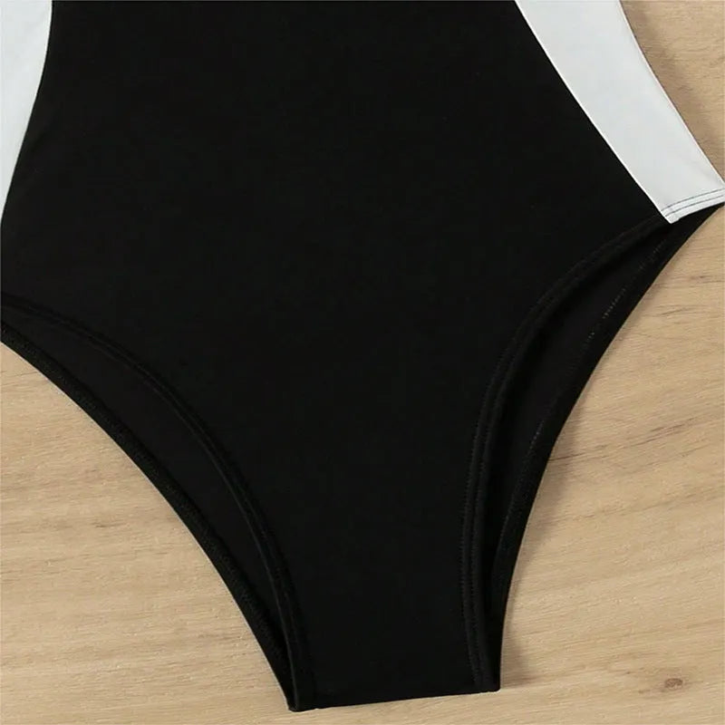 Black and white women's one-piece swimsuit with slim fit and pearl spaghetti straps on a mannequin.