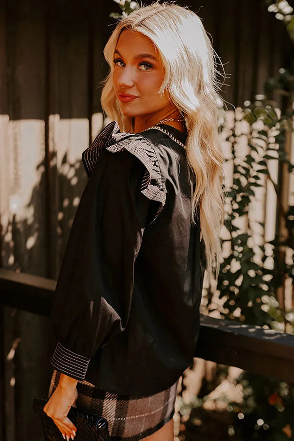 Black women's V-neck blouse with contrast stitching and ruffle long sleeves