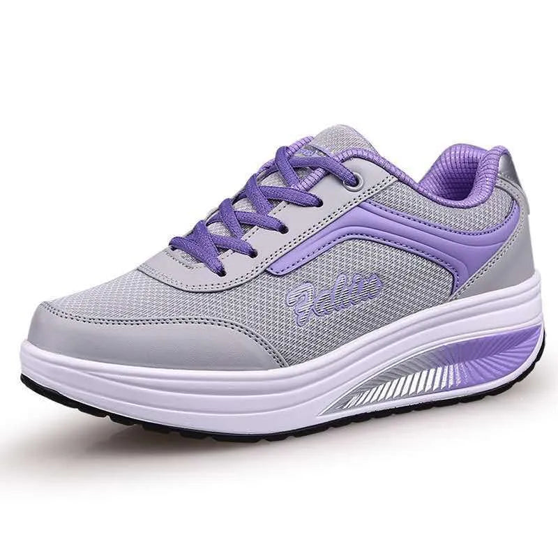 Women's grey pink heelless sports travel shoes with a mid heel on a neutral background.