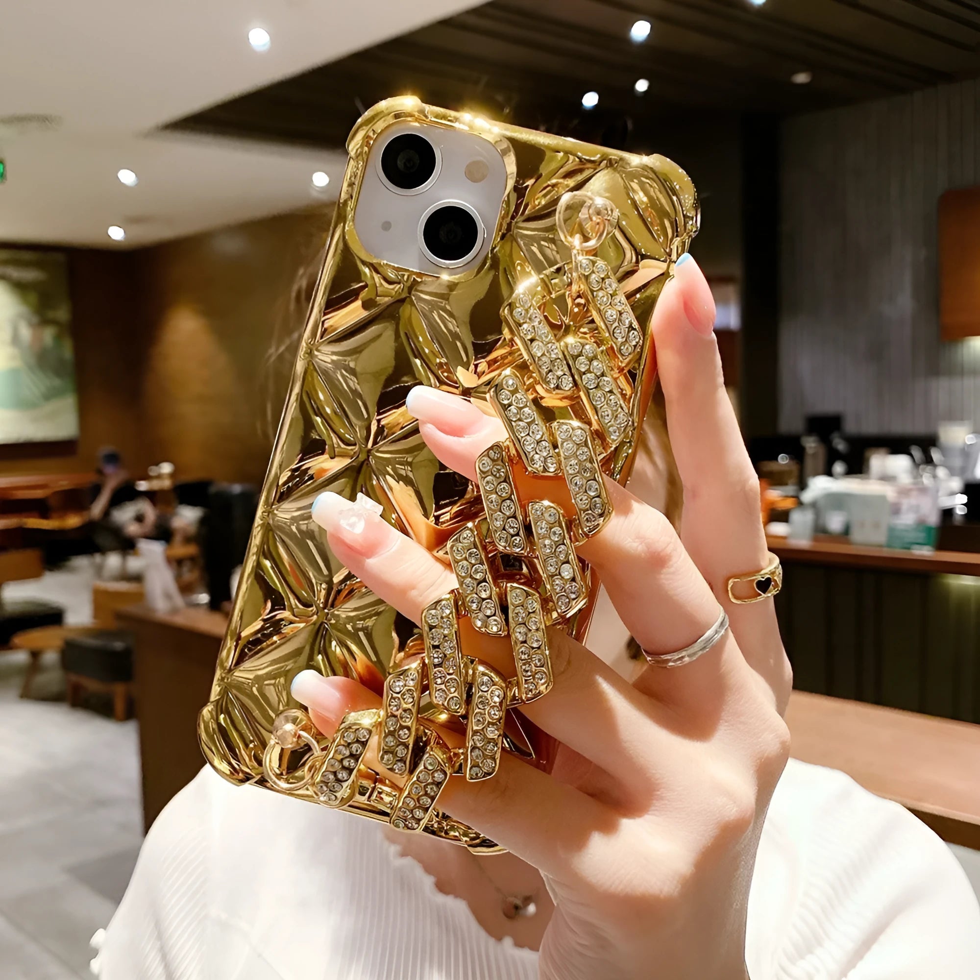 Gold diamond bracelet attached by chain to a TPU phone case for iPhone.