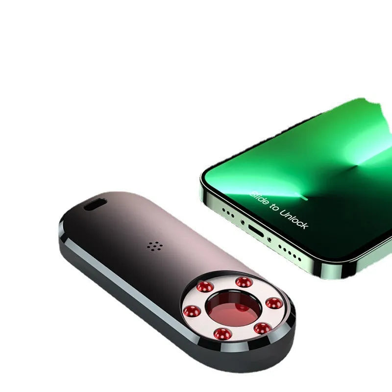 AK400 portable infrared anti-monitoring detector with USB cable on a table.