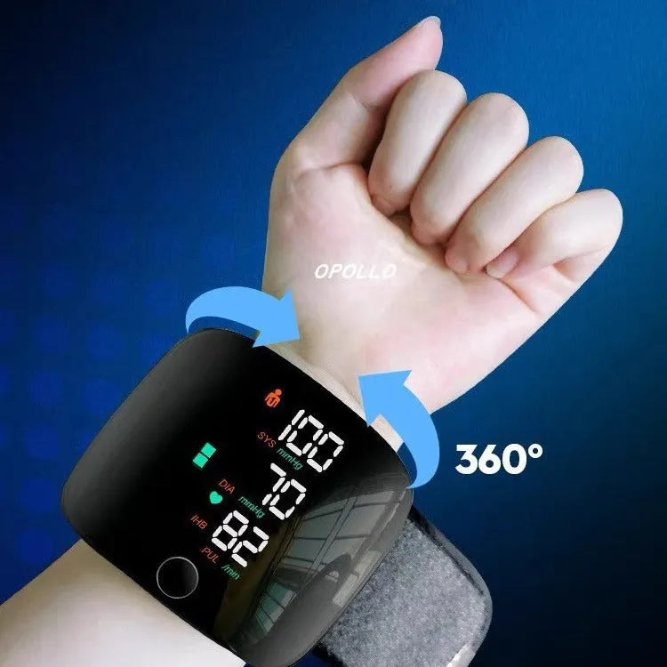 Black wrist blood pressure monitor with digital display, shown with USB charging cable.
