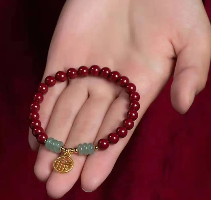 Gold cinnabar and copper bead bracelet in a wave shape on a wrist.