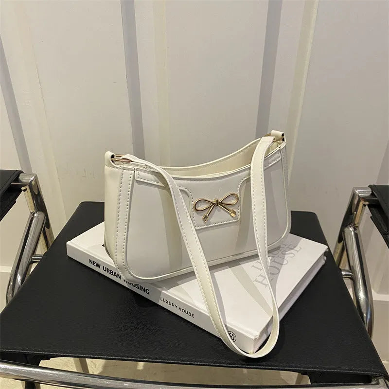 Western style PU leather shoulder bag with bow detail in horizontal square shape.