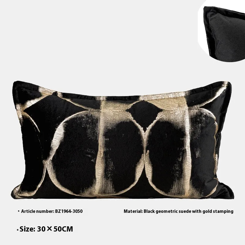 Black and gold abstract patterned flannel sofa cushion with removable cover on a grey sofa.