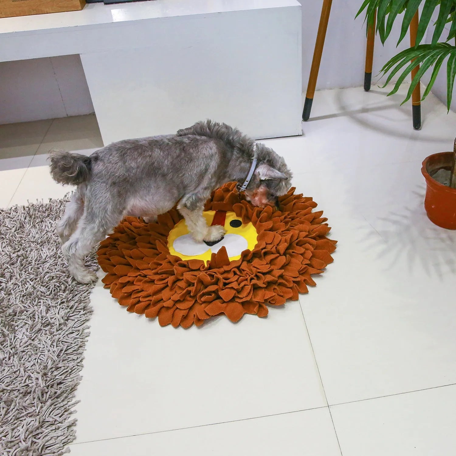 Brown lion face pattern snuffle mat for dogs and cats on a floor.