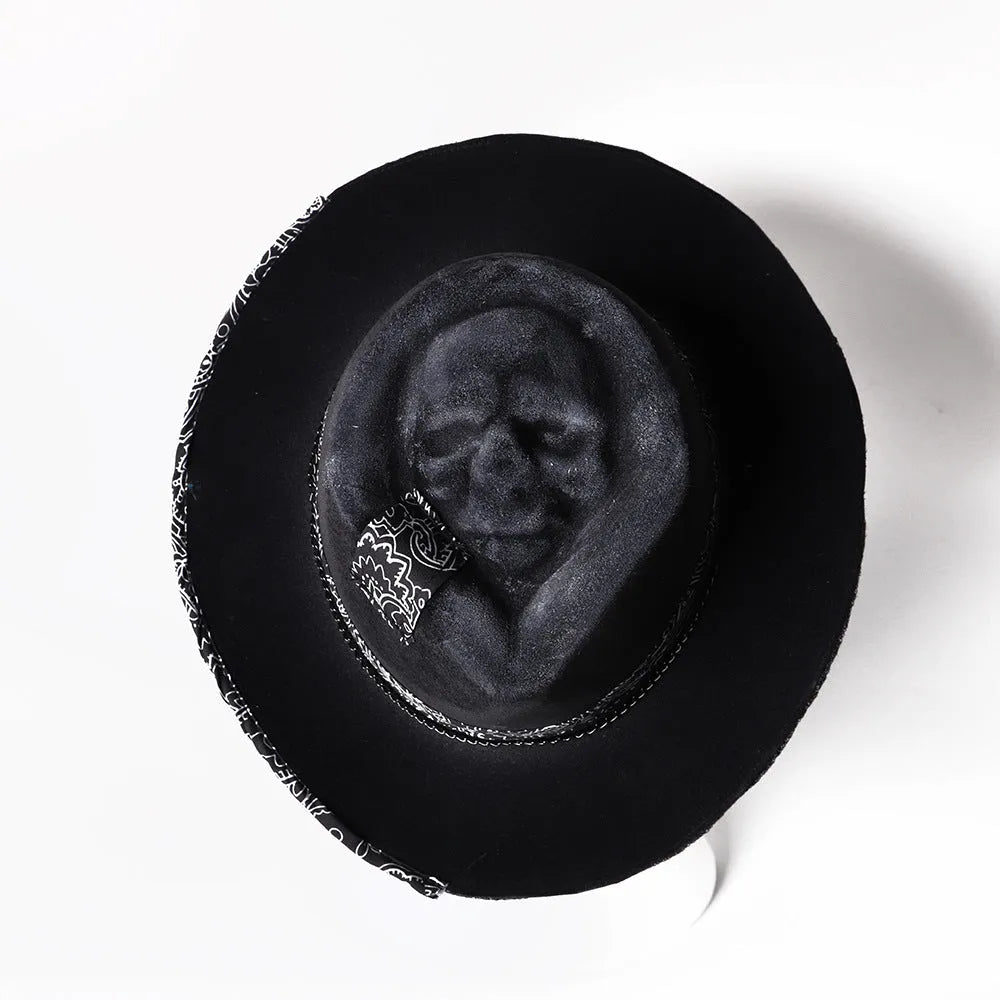 Handmade wool felt skull hat with a conical crown on a neutral background