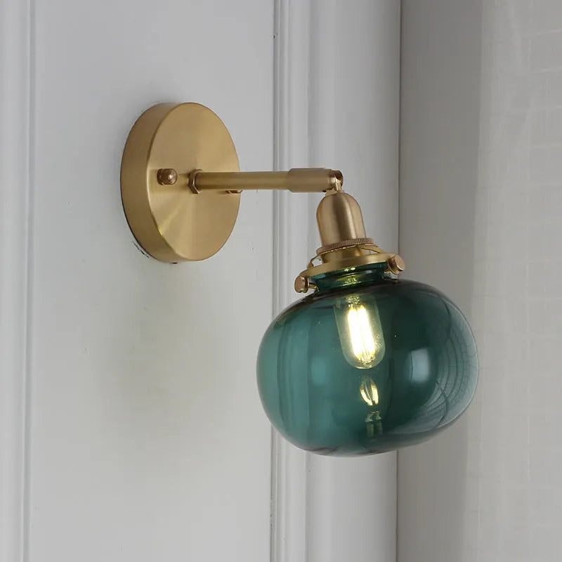 Pumpkin-shaped glass wall lamp with a curved shade on a wall, shown in water ripple transparent and solid blue glass options.