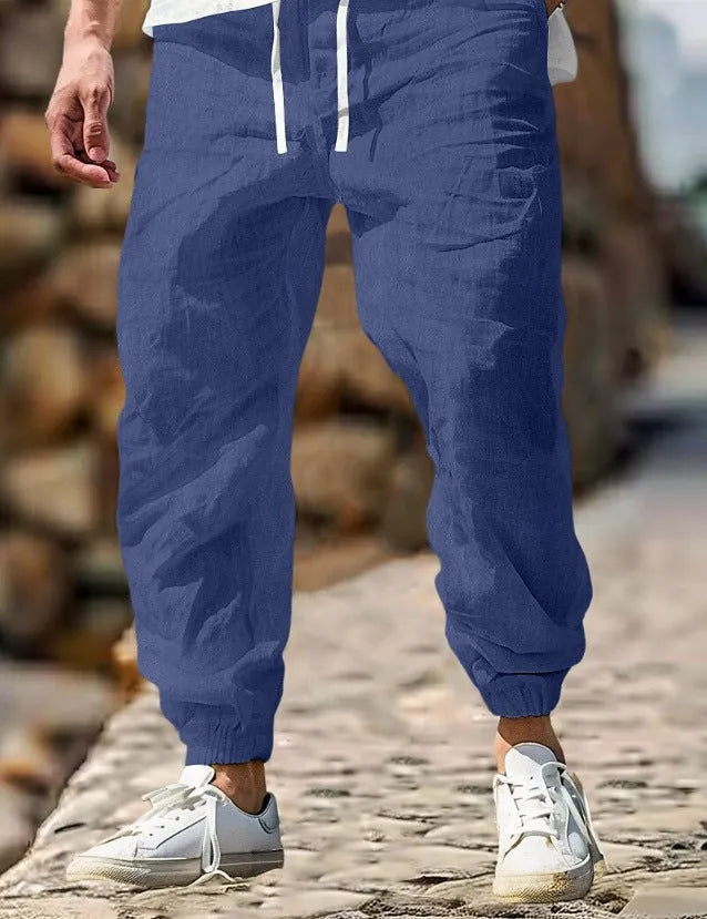 Men's beige straight leg linen trousers with elastic waistband laid flat