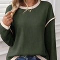 Women's beige knit top with four leaf clover pattern, contrast trim, and drop shoulder loose fit