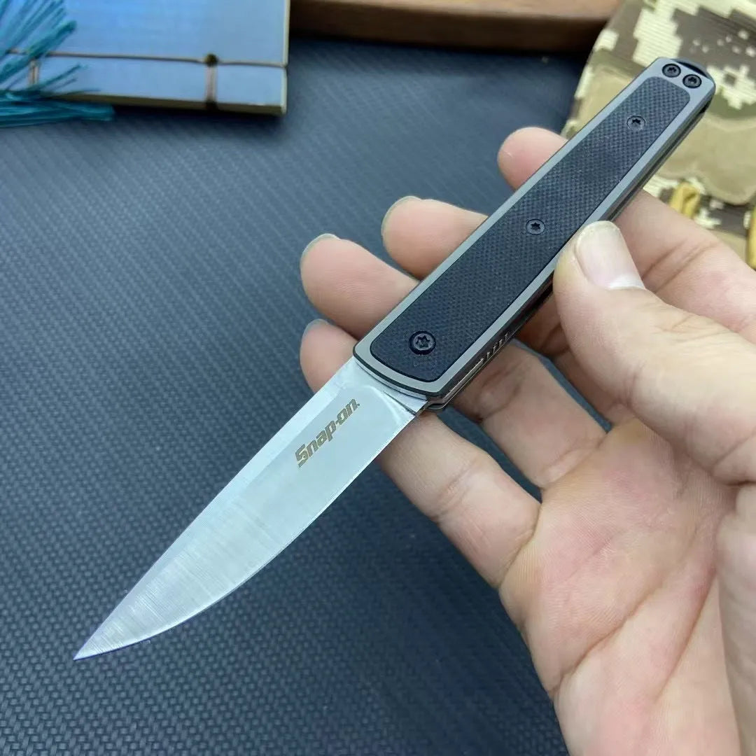 Closed and open views of a black folding fruit knife showing blade and handle.