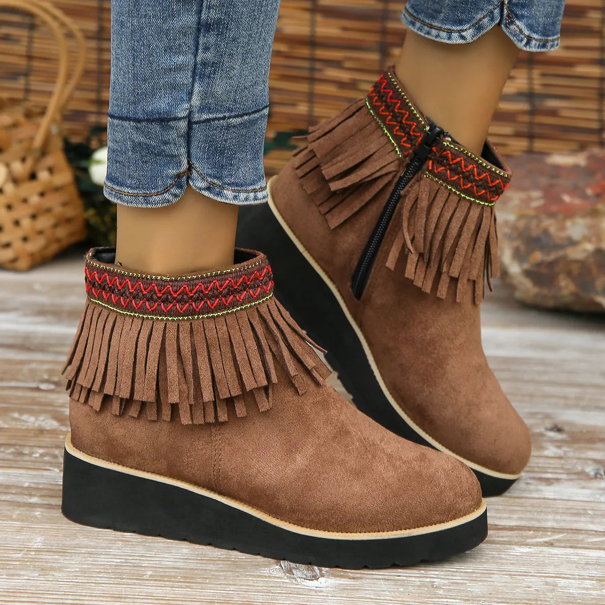 Women's dark brown suede wedge bootie with thick sole, side zipper, and tassel detail.