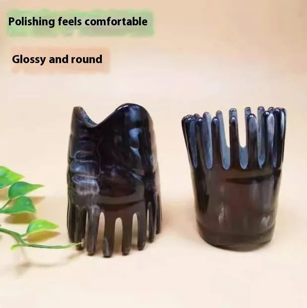 A white buffalo horn comb with wide teeth and a pointed tip for scalp massage.