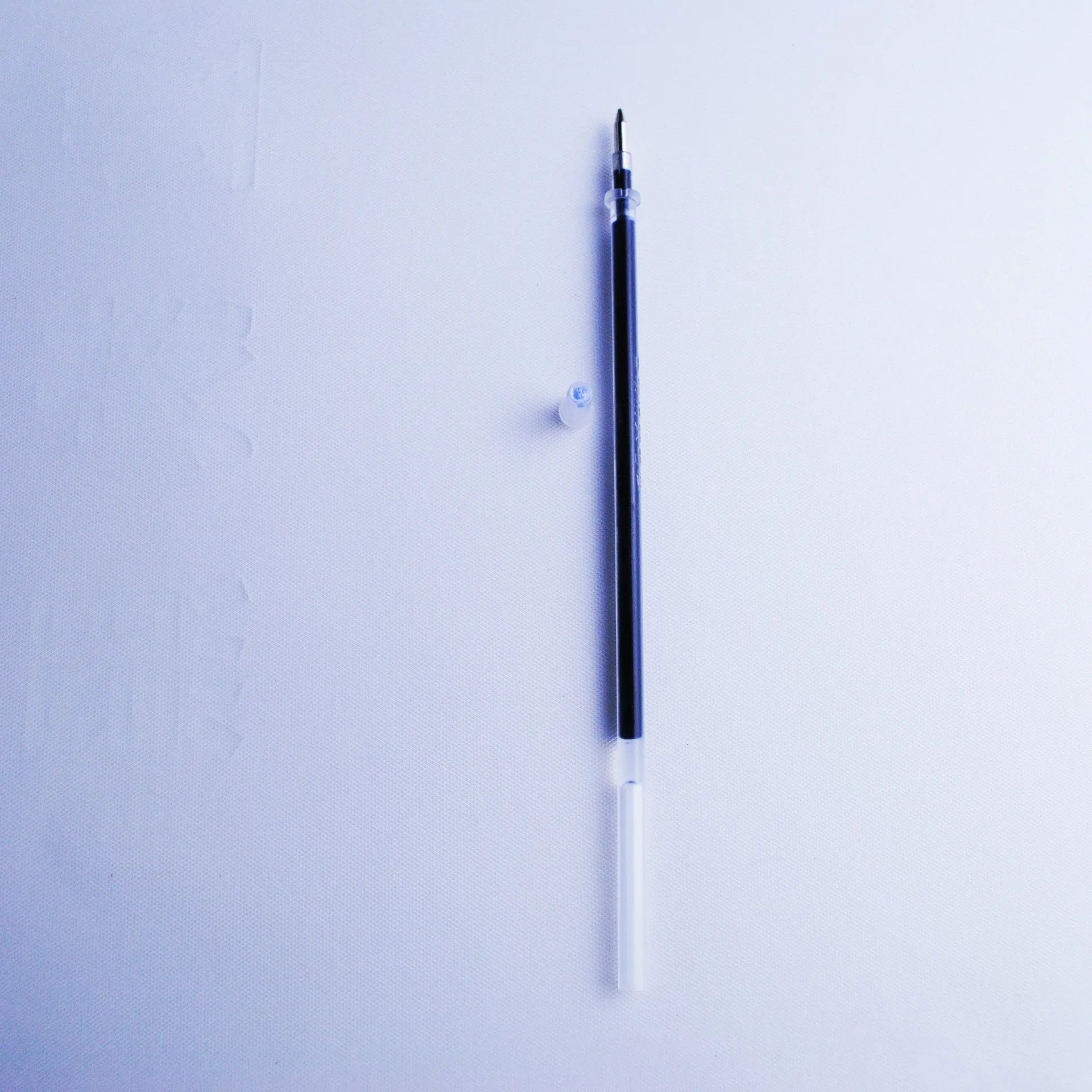 Automatic fading pen set with blue 0.5mm refills and pen holder on white background.