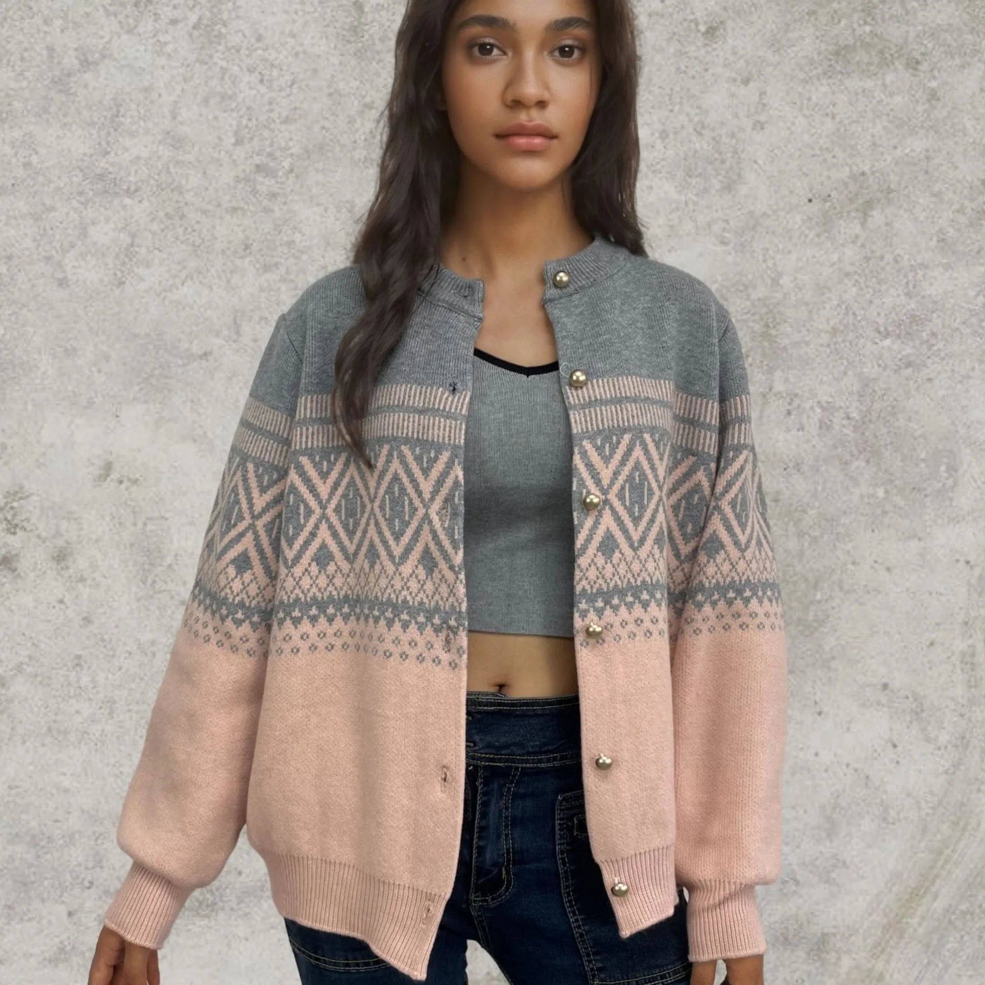 Woman wearing a grey alpaca wool cardigan with a long sleeve diamond pattern in a contrast colour.