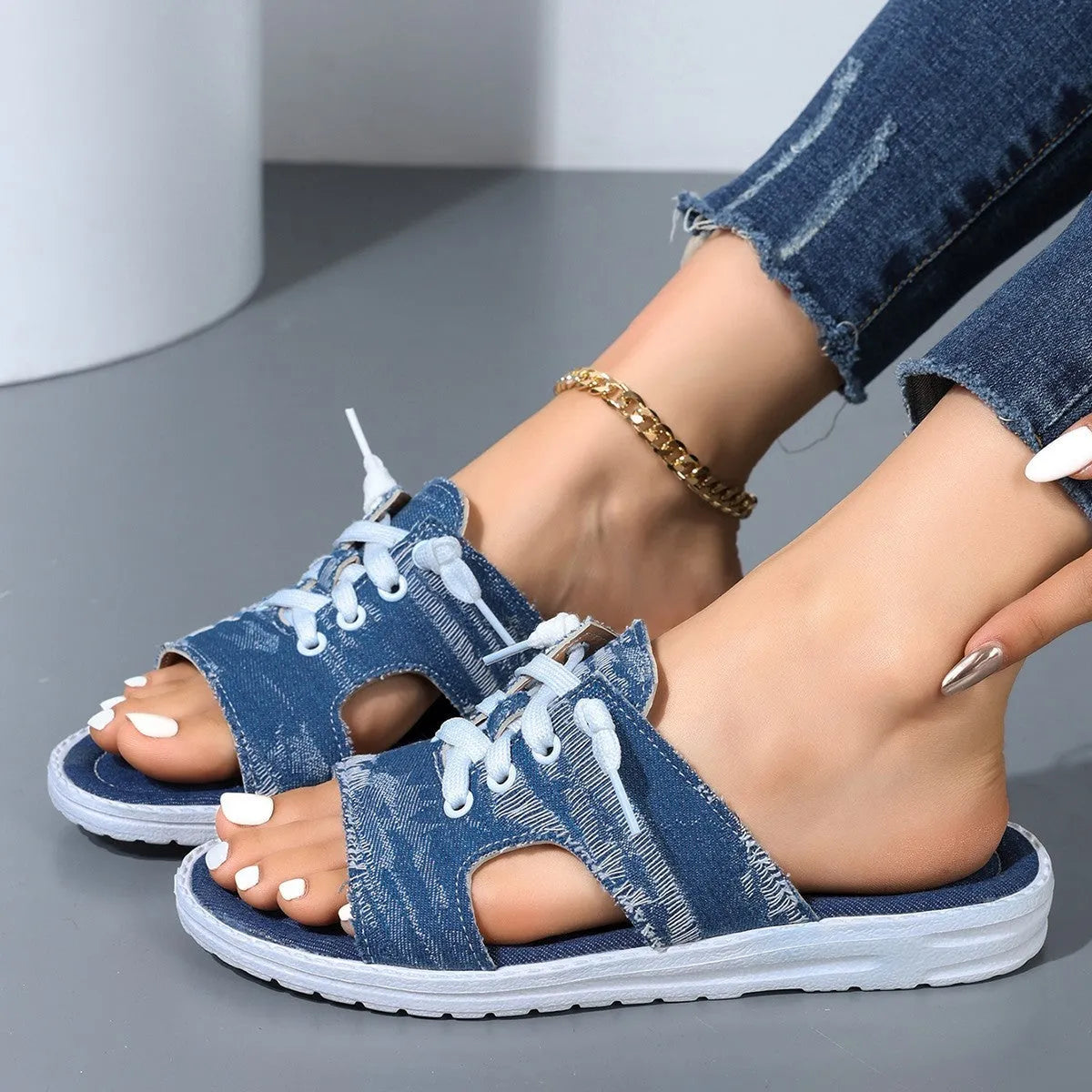 Blue women's flat canvas Roman style slippers with a cloth upper and rubber sole.