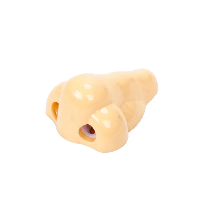 Flesh coloured plastic pencil sharpener with big nostril hole showing compact geometry shape