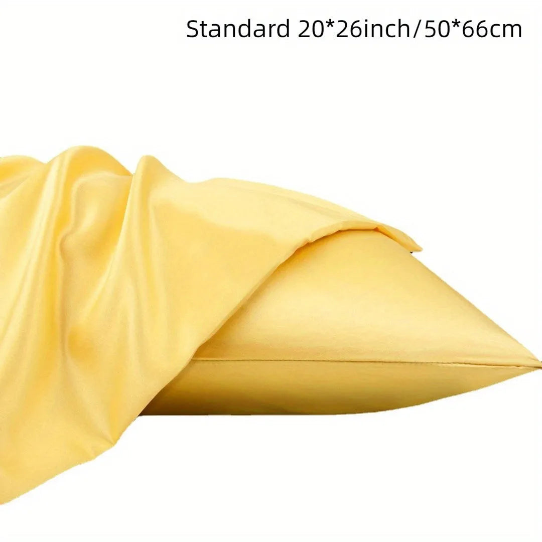 A pair of solid colour satin pillowcases in various colours and sizes on a bed.