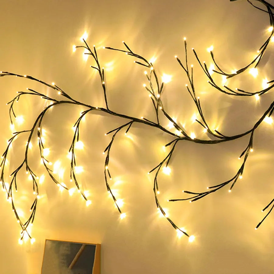 Flexible willow vine LED garland with birch bark texture and warm white lights shaped on a wall.