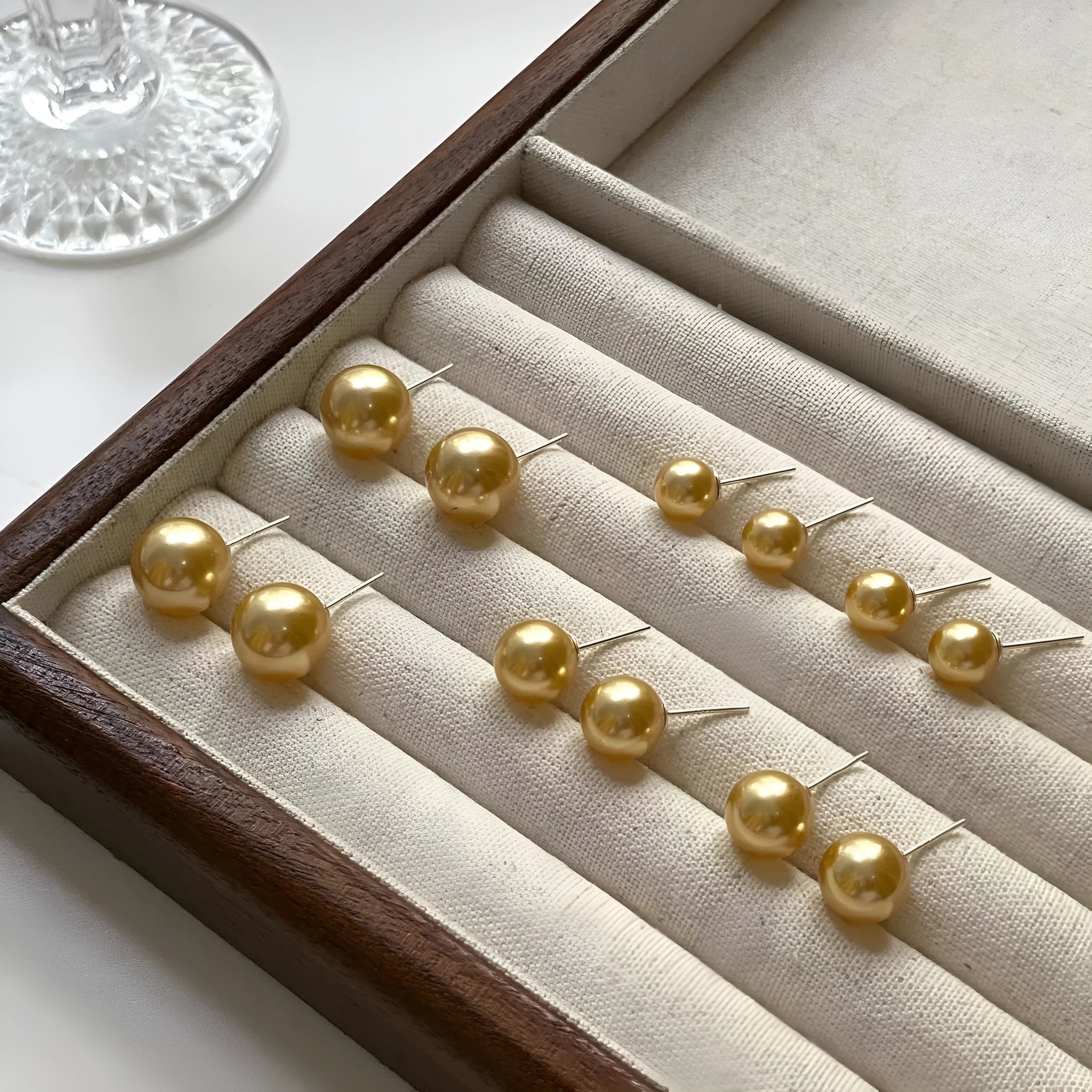 A pair of large geometric pearl stud earrings with a retro eight awn star motif on a silver setting.