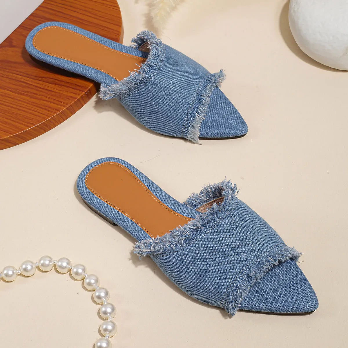 Women's denim flat slippers with tassel detail and leather lining in various colours.