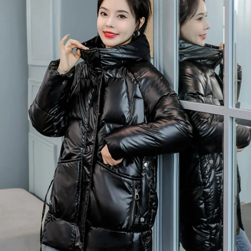 A woman wears a loose-fitting green hooded winter jacket with long sleeves.