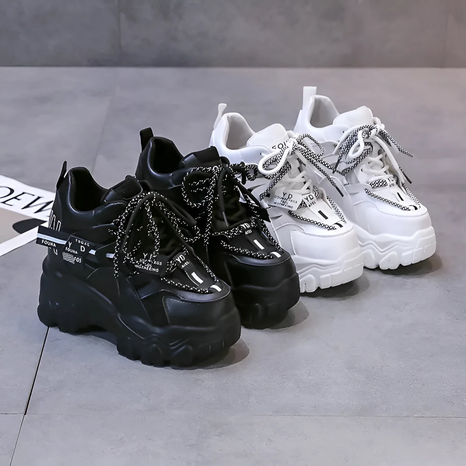 White and black women's low-top mesh platform sports shoes with cross strap and round toe.