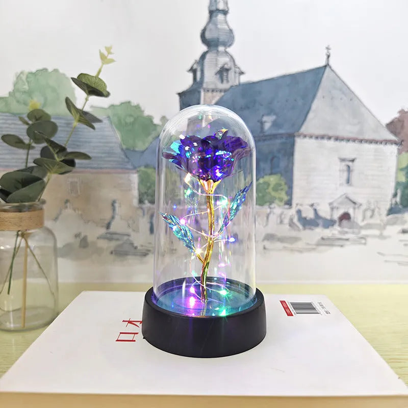 Small plastic night lamp with floral decoration and coloured light options on a black base.