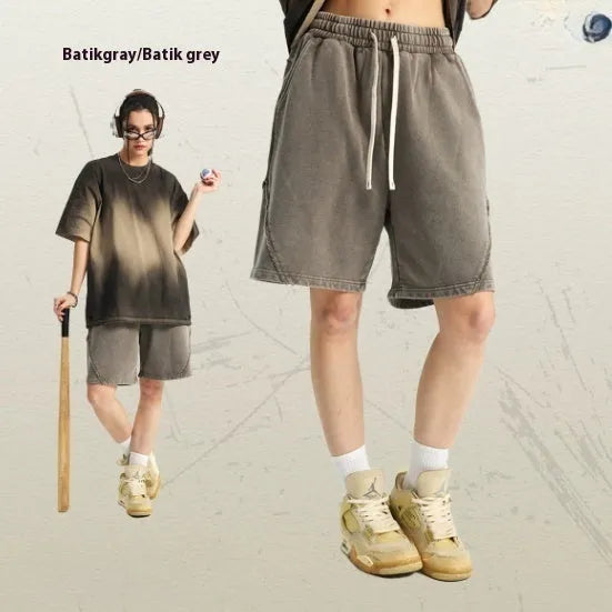 Man wearing loose fit batik-dyed cotton terry shorts in a casual street fashion setting.