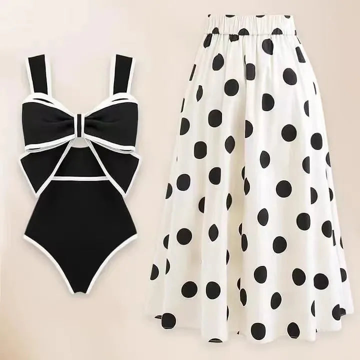 Black one-piece women's swimsuit with a flared round skirt and a decorative bow on the front.