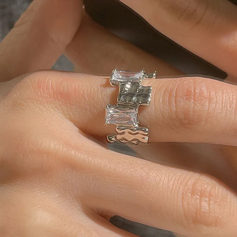 Silver geometric zircon cross ring with open centre and retro design