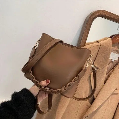 Retro khaki crossbody bucket bag with woven PU detailing and adjustable strap.