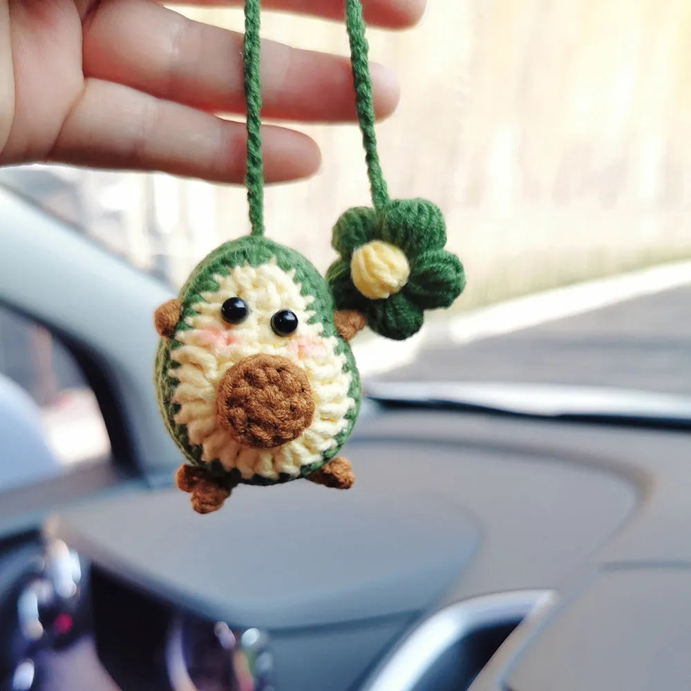 Handmade crocheted car pendant with avocado and rainbow colours hanging from rear-view mirror