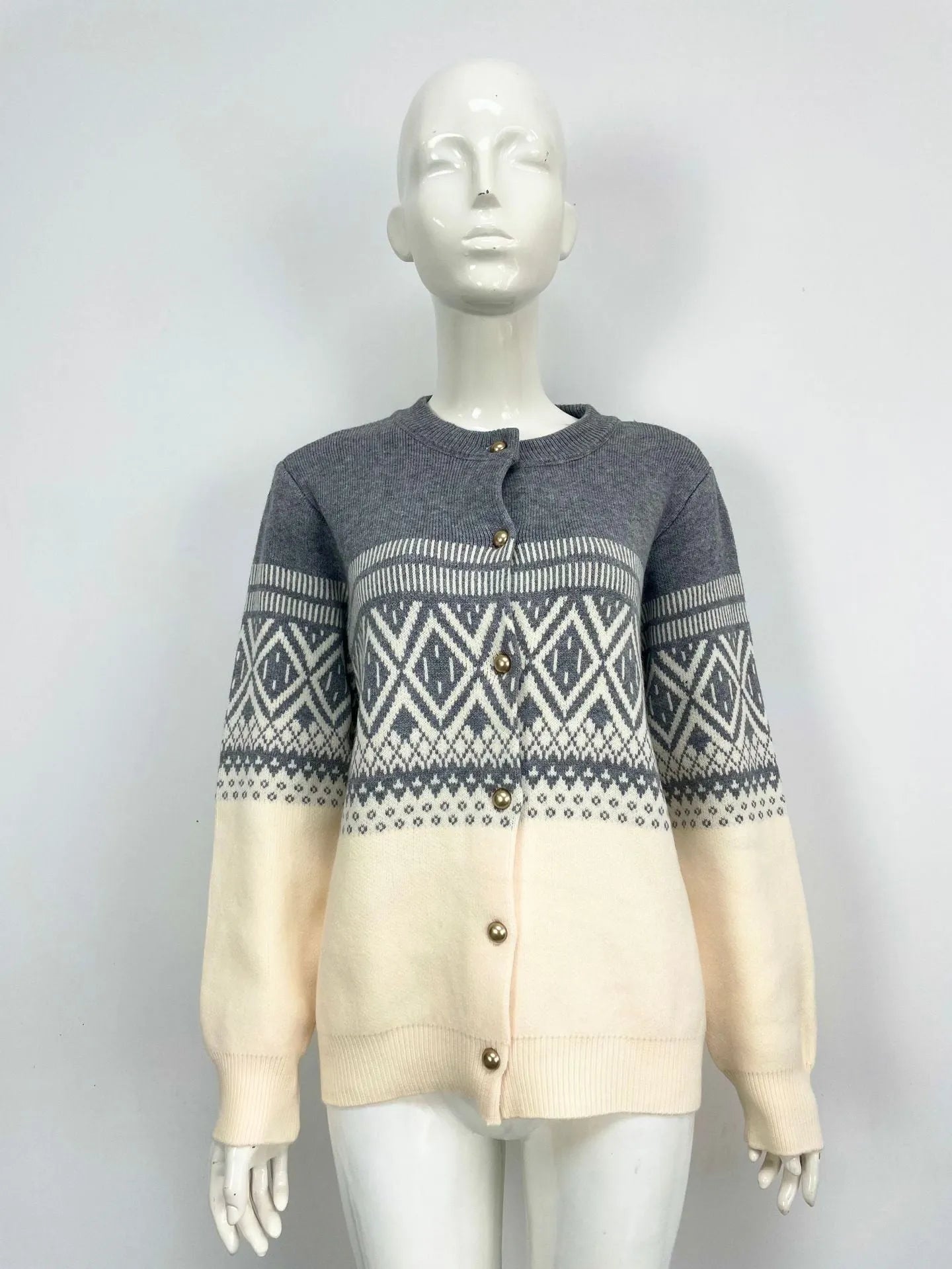 Woman wearing a grey alpaca wool cardigan with a long sleeve diamond pattern in a contrast colour.