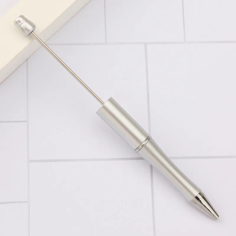 Creative ballpoint pen with multicoloured spinning plastic beads on a steel wire frame.