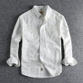 Men's solid colour cotton long sleeve shirt in a cardigan style on a hanger.