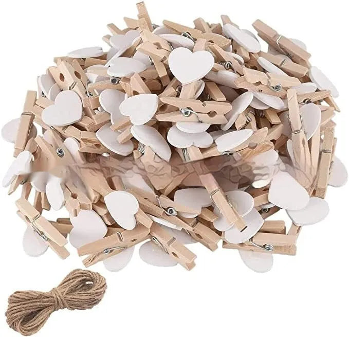 Five small handmade solid wood heart-shaped clips in assorted colours on a white surface.